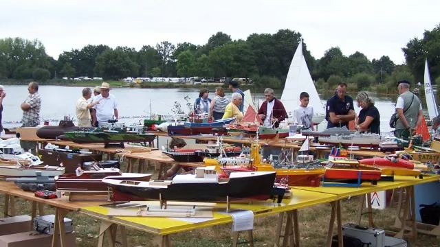 Exposition de maquettes de bateaux sur une grande table devant le lac de la Chausselière à Montaigu-Vendée